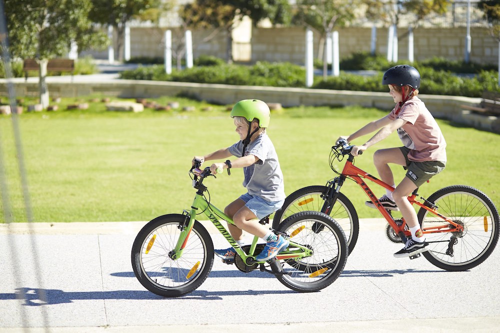 jindee kids on bikes riding past park houses jindalee land for sale